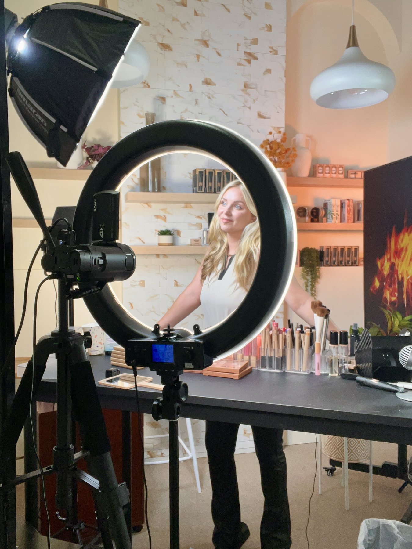 Behind the scenes at a live shopping production — ring light, 4K camera, full makeup setup
