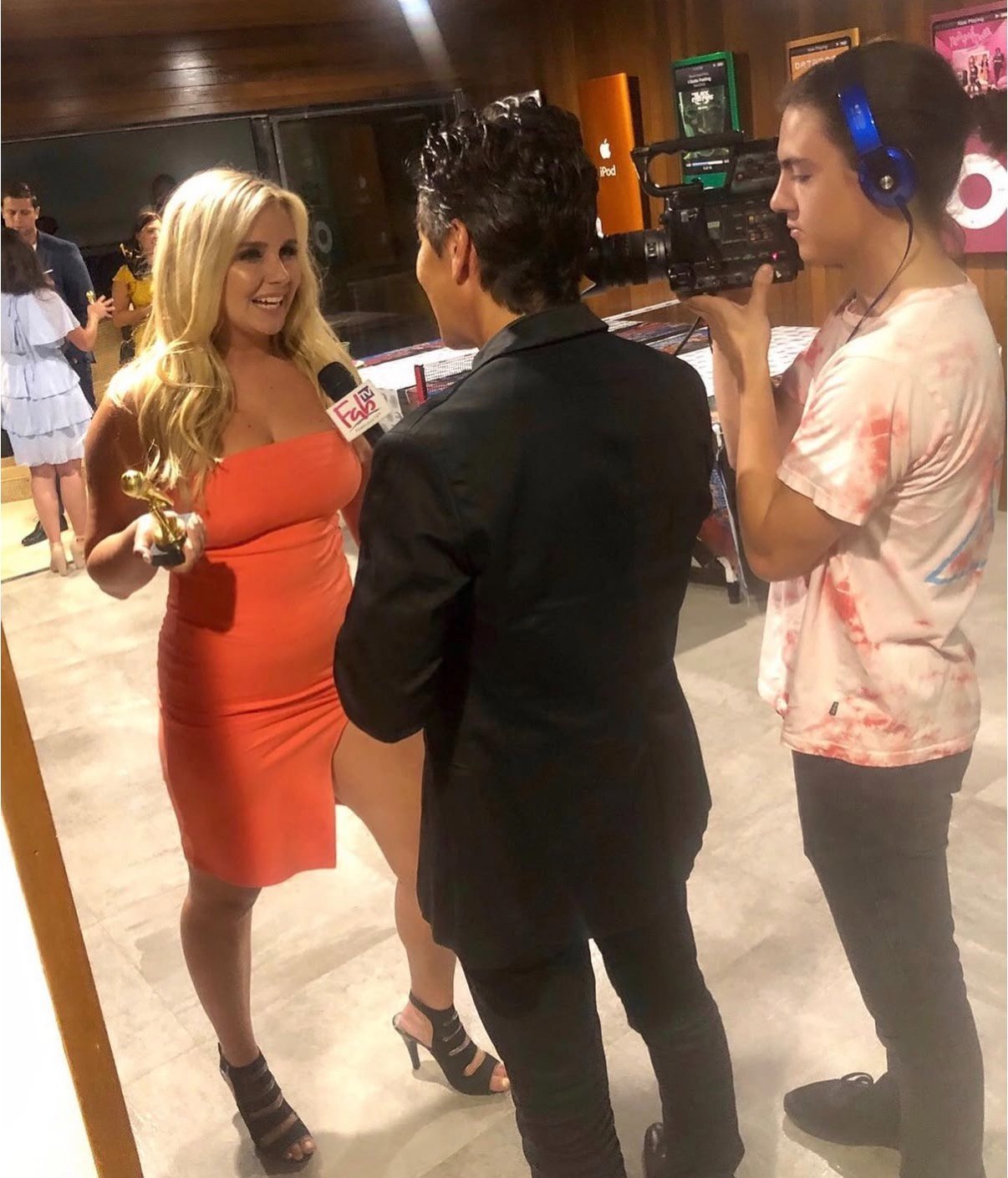 Jessica O'Connor conducting an on-camera red-carpet interview with a FabTV microphone