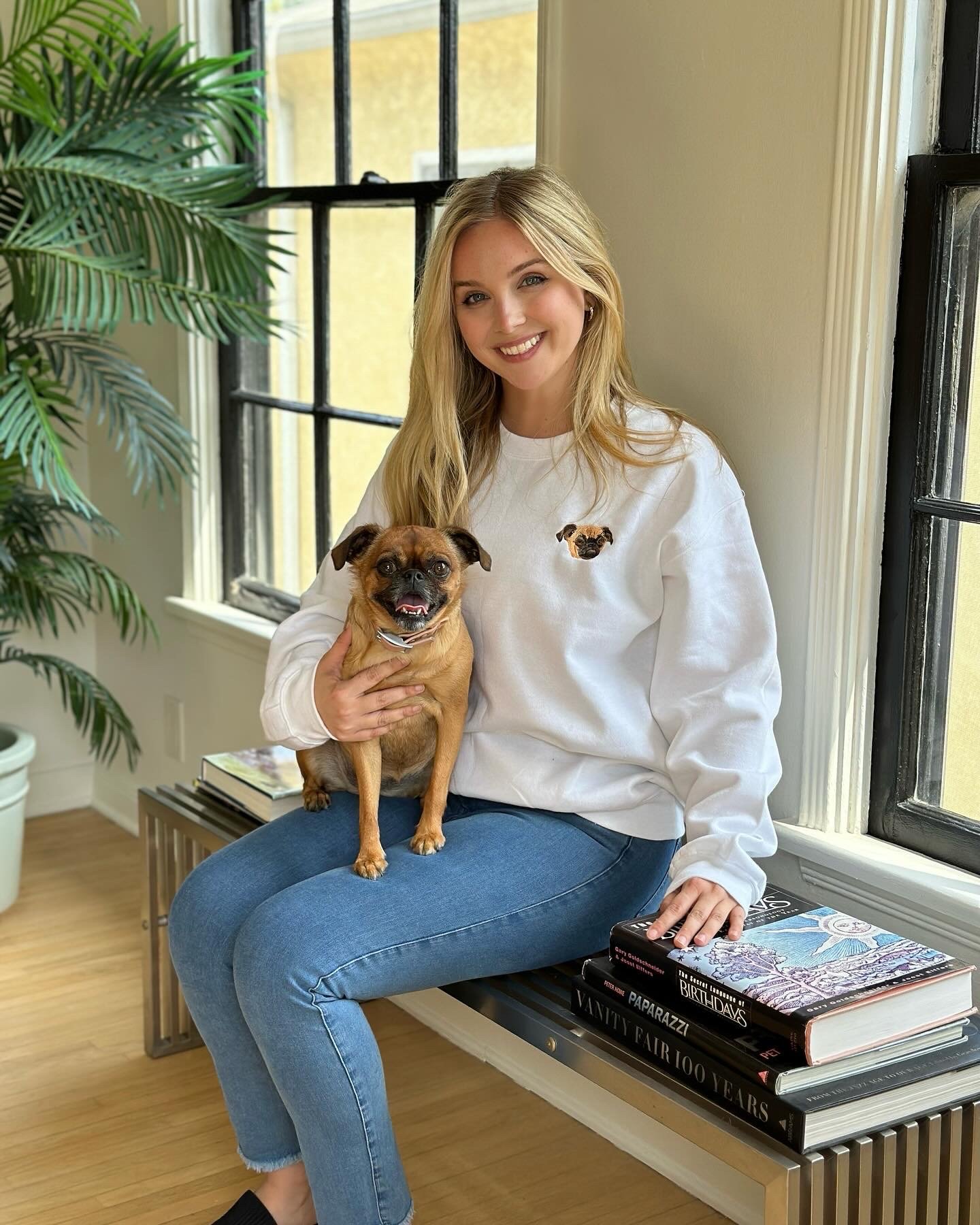 West & Willow lifestyle campaign — Jessica O'Connor in a white embroidered sweatshirt on a window bench with her dog Keke